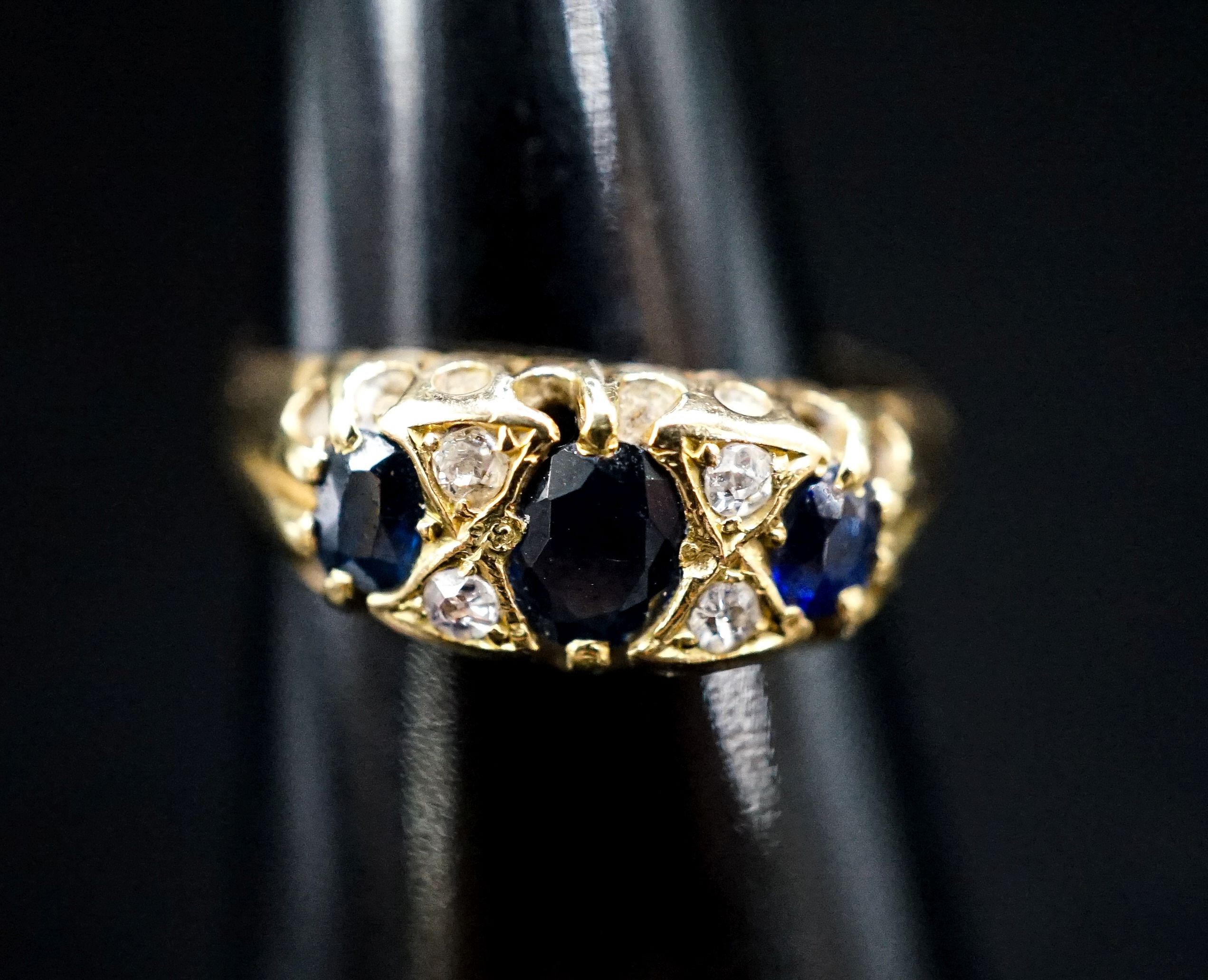 A late Victorian 18ct gold, three stone sapphire and four stone diamond chip set ring, size L, gross weight three grams.